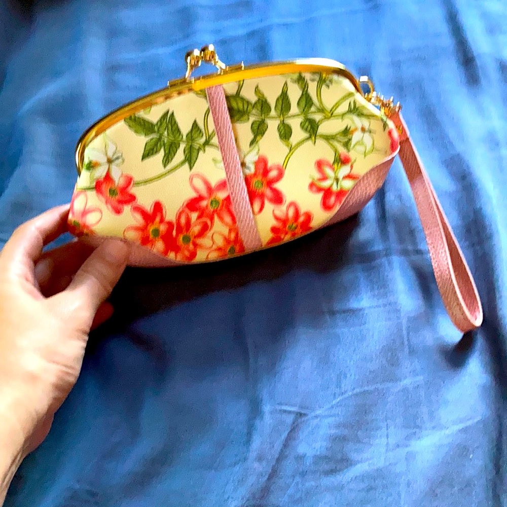 Small pink floral clutch with strap. Green inner lining